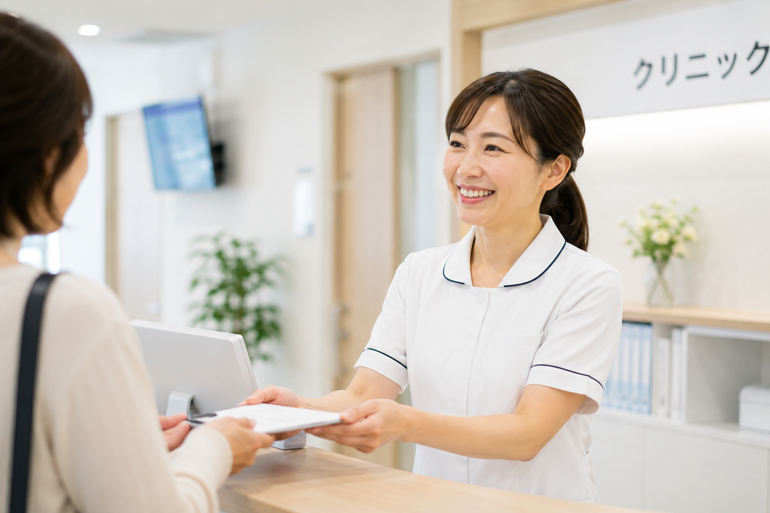 体力的な負担が少ないクリニックの受付で、身体の痛みに悩まされることなく笑顔で働く40代看護師